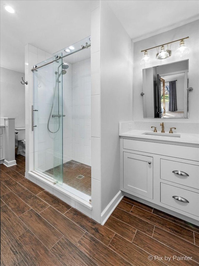 bathroom featuring vanity, toilet, and a shower with shower door