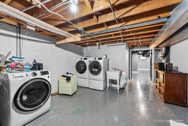 clothes washing area with washer and dryer and sink