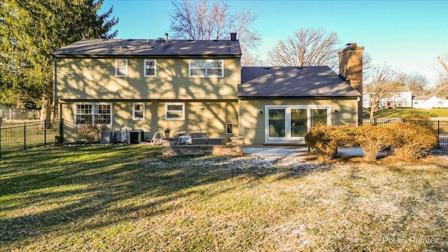 rear view of property featuring central AC and a yard