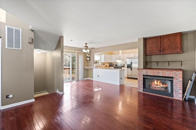 unfurnished living room with ceiling fan, a fireplace, and wood-type flooring