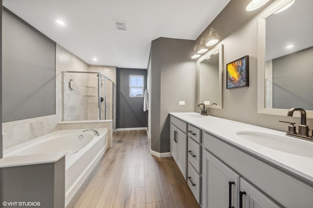 bathroom with vanity, independent shower and bath, and hardwood / wood-style flooring