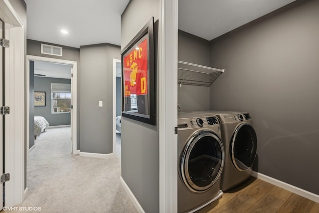 clothes washing area featuring light wood-type flooring and washing machine and dryer