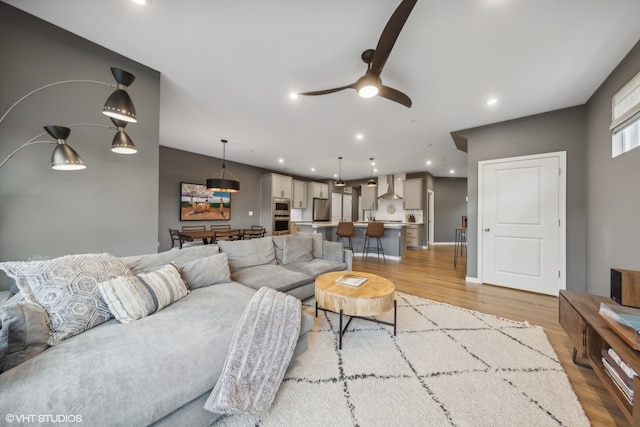 living room with ceiling fan and light wood-type flooring