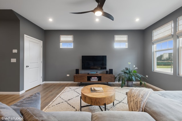 living room with light hardwood / wood-style flooring and ceiling fan