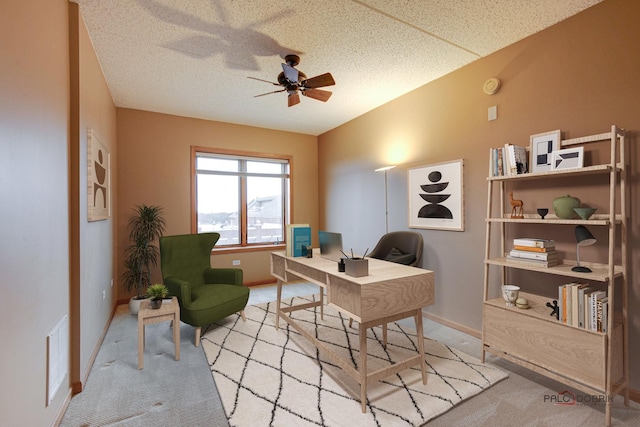 carpeted home office featuring ceiling fan and a textured ceiling