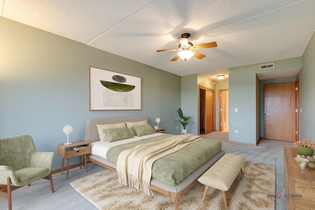 bedroom with a closet, a textured ceiling, light colored carpet, and ceiling fan