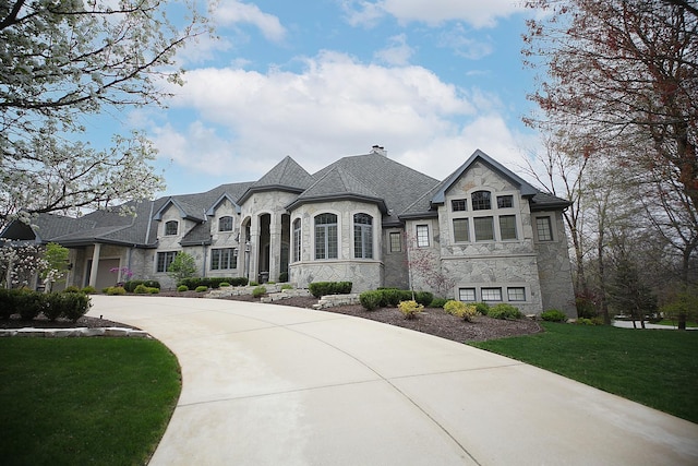 french country inspired facade featuring a front yard