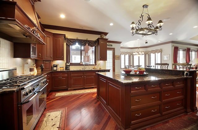 kitchen featuring range with two ovens, dark stone countertops, a notable chandelier, dark hardwood / wood-style flooring, and custom range hood