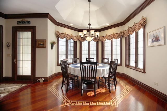 dining area with a tray ceiling, dark hardwood / wood-style flooring, a chandelier, and ornamental molding