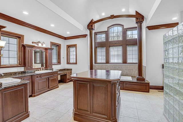 bathroom featuring vanity, crown molding, vaulted ceiling, tile patterned flooring, and ornate columns