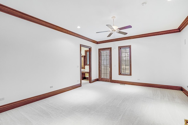 spare room featuring ceiling fan, light colored carpet, and ornamental molding