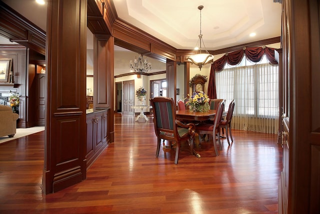 dining room with a tray ceiling, crown molding, dark hardwood / wood-style floors, and a notable chandelier