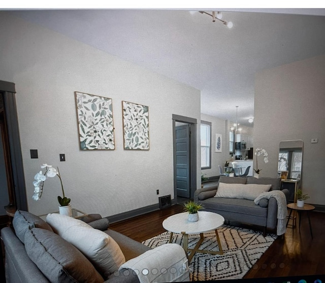 living room with a chandelier and dark hardwood / wood-style flooring