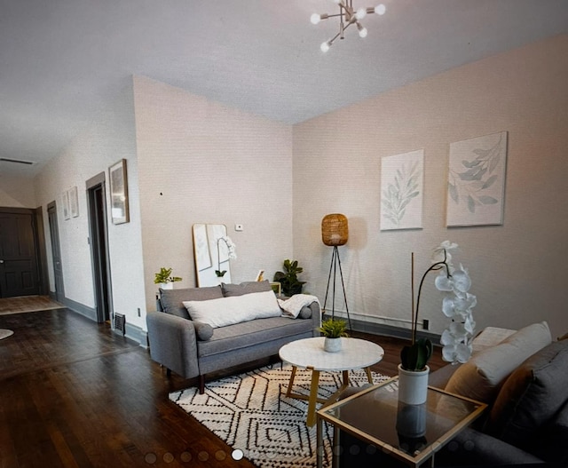 living room with a chandelier, dark wood-type flooring, and lofted ceiling