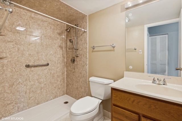 bathroom with vanity, toilet, and a tile shower