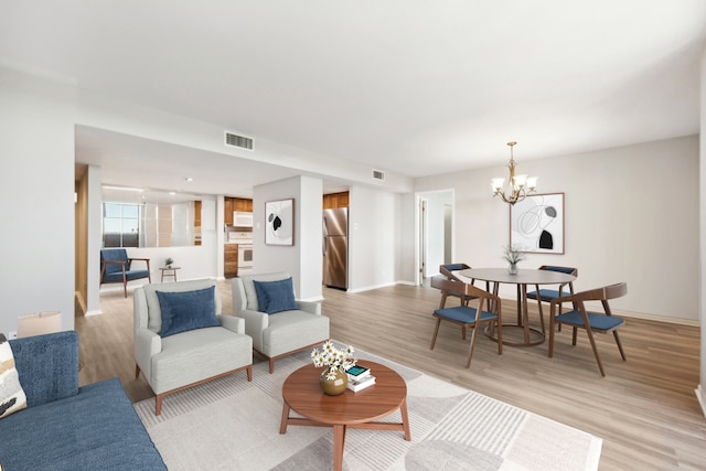 living room featuring a chandelier and light hardwood / wood-style floors