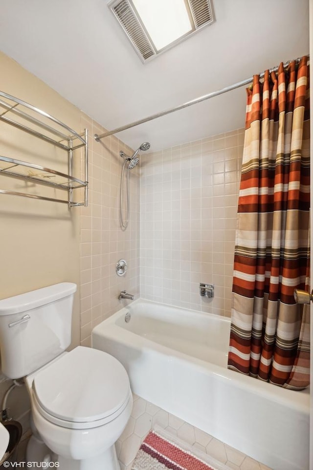 bathroom featuring shower / bath combination with curtain, tile patterned floors, and toilet