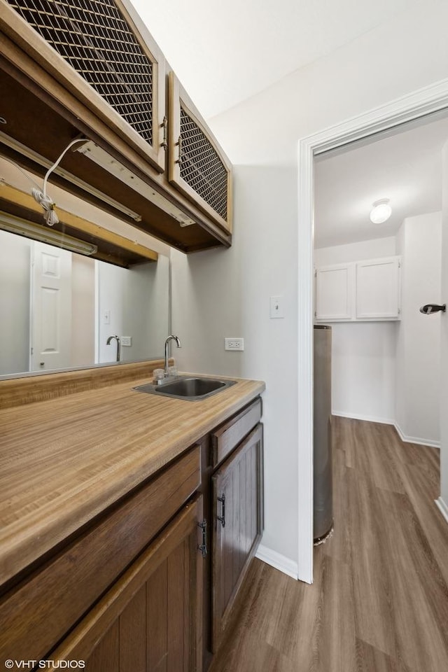 kitchen with white cabinetry, light hardwood / wood-style floors, and sink