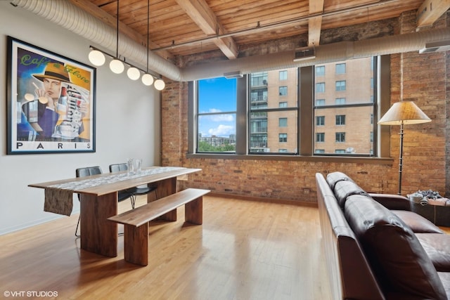 dining space featuring beam ceiling, light wood-type flooring, wood ceiling, and brick wall