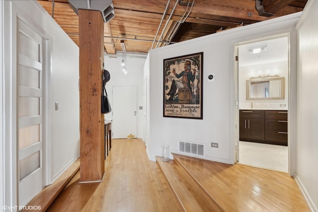 hallway with light hardwood / wood-style floors and wooden ceiling