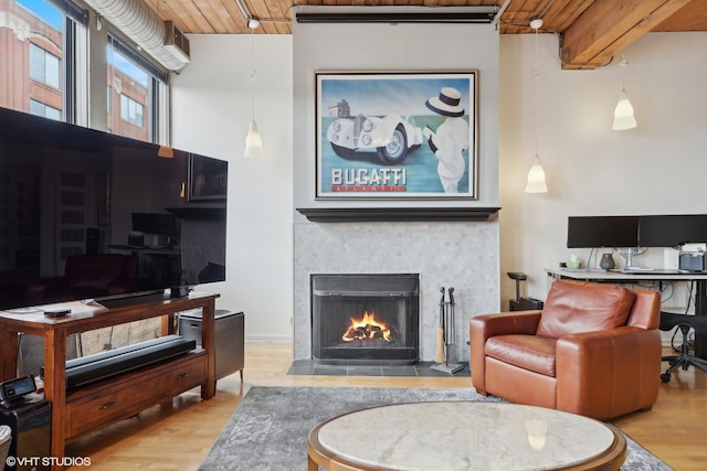 living room with beam ceiling, wooden ceiling, a fireplace, and wood-type flooring