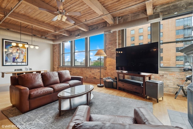 living room with beamed ceiling, light wood-type flooring, wood ceiling, and brick wall