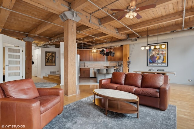 living room featuring beamed ceiling, light wood-type flooring, ceiling fan, and wood ceiling