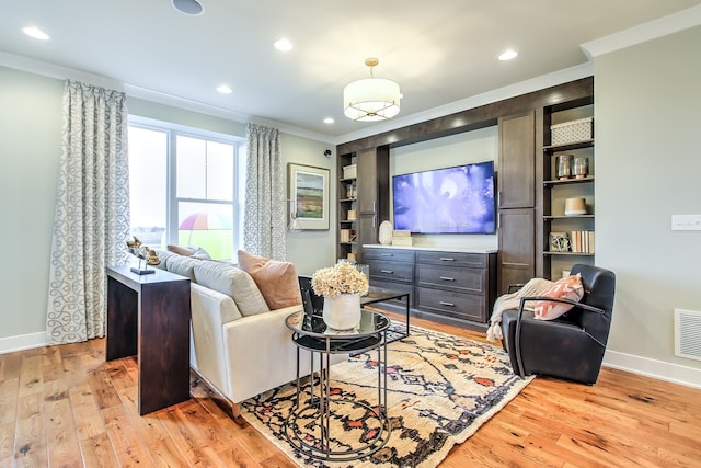 living room featuring crown molding and light hardwood / wood-style flooring