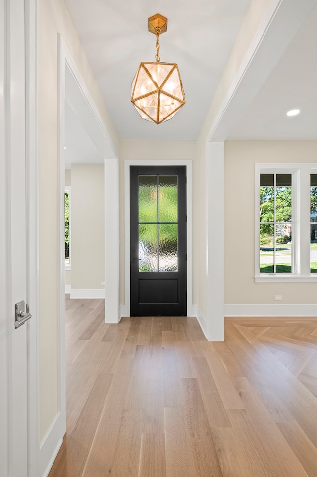 entryway featuring a chandelier, a healthy amount of sunlight, and light wood-type flooring