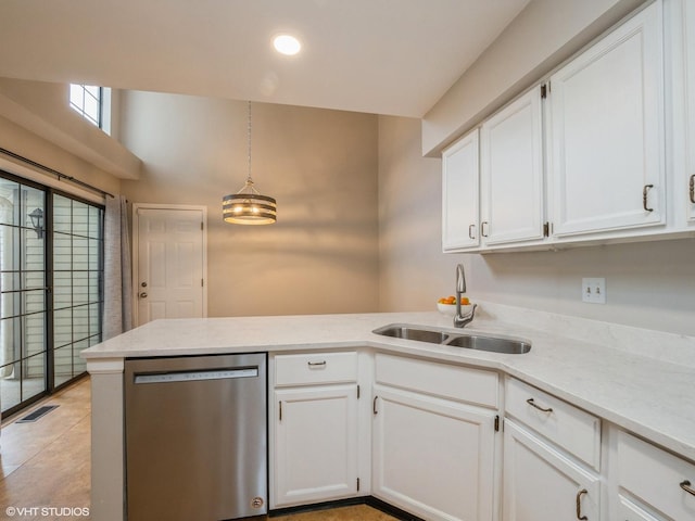 kitchen featuring decorative light fixtures, stainless steel dishwasher, white cabinetry, and sink