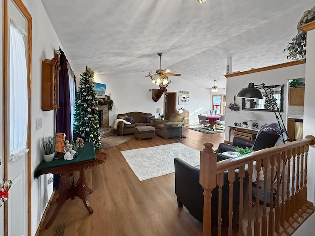 living room with a textured ceiling, hardwood / wood-style flooring, and lofted ceiling