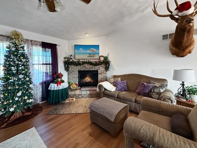 living room featuring hardwood / wood-style floors and a brick fireplace