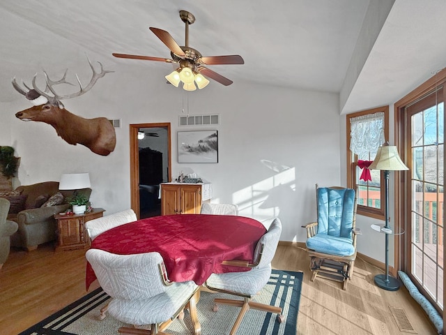 dining space with ceiling fan, vaulted ceiling, and light wood-type flooring