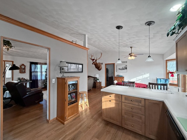 kitchen featuring decorative light fixtures, dishwasher, light wood-type flooring, and a textured ceiling