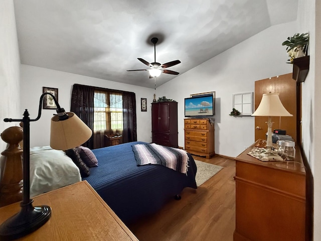 bedroom with ceiling fan, light hardwood / wood-style flooring, and vaulted ceiling