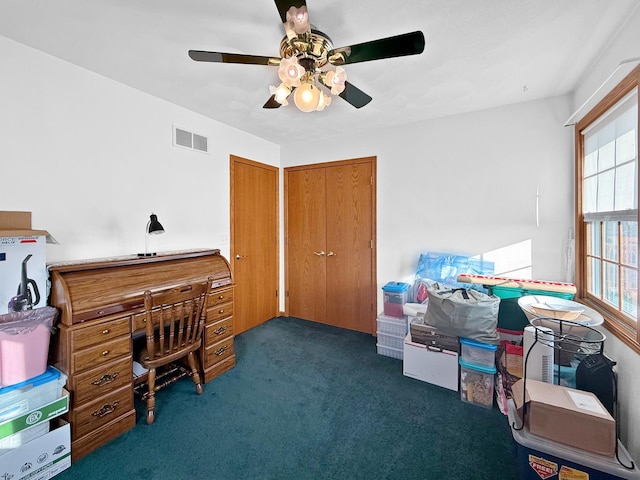 office area with ceiling fan and dark colored carpet