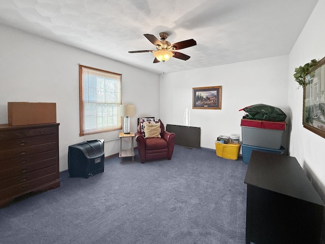 sitting room with dark carpet and ceiling fan