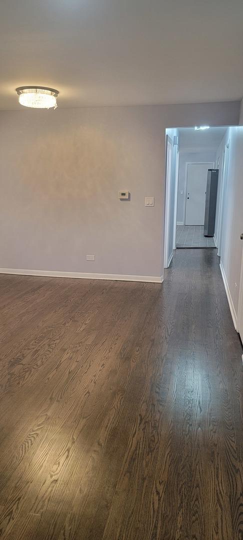 empty room with dark hardwood / wood-style flooring