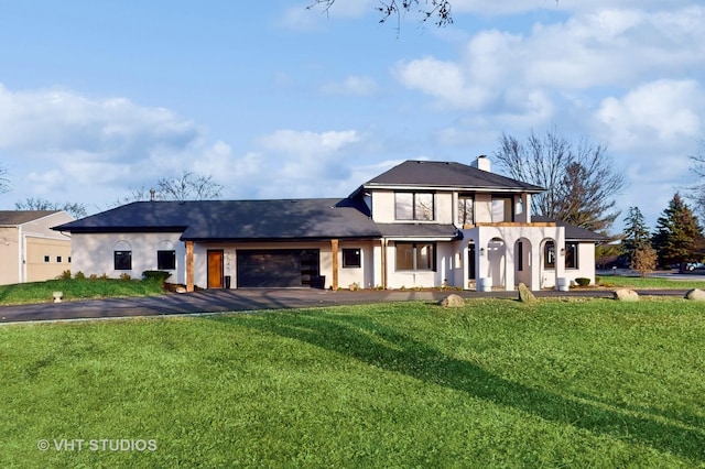 view of front of house featuring a garage and a front lawn