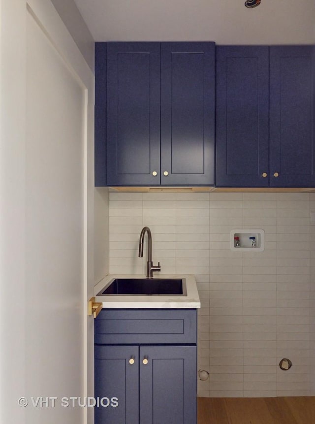 laundry area with hookup for a washing machine, sink, and hardwood / wood-style flooring