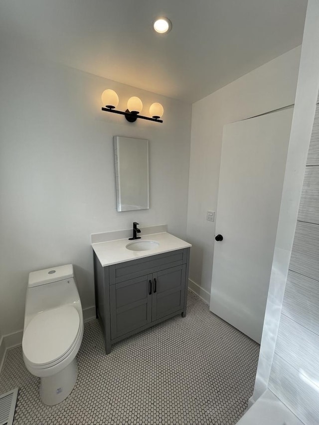 bathroom featuring tile patterned flooring, vanity, and toilet