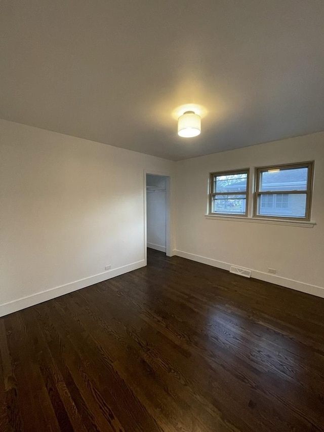 spare room with dark wood-type flooring