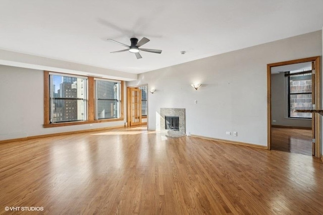 unfurnished living room featuring ceiling fan, a healthy amount of sunlight, and light hardwood / wood-style flooring