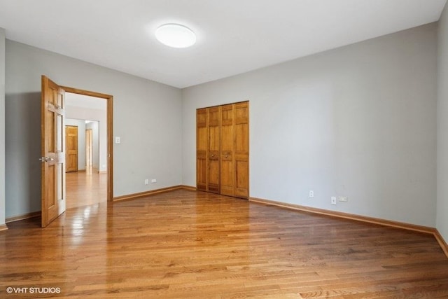 unfurnished bedroom with light wood-type flooring and a closet