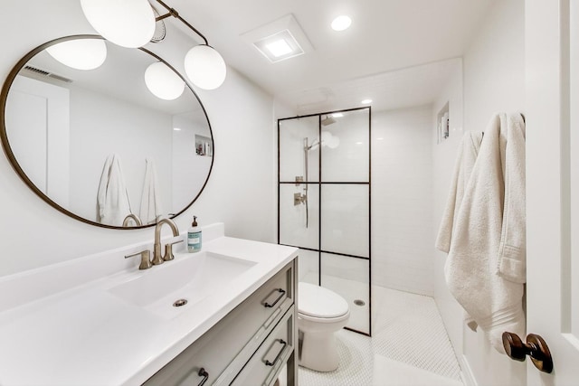 bathroom featuring toilet, vanity, tile patterned flooring, and a tile shower