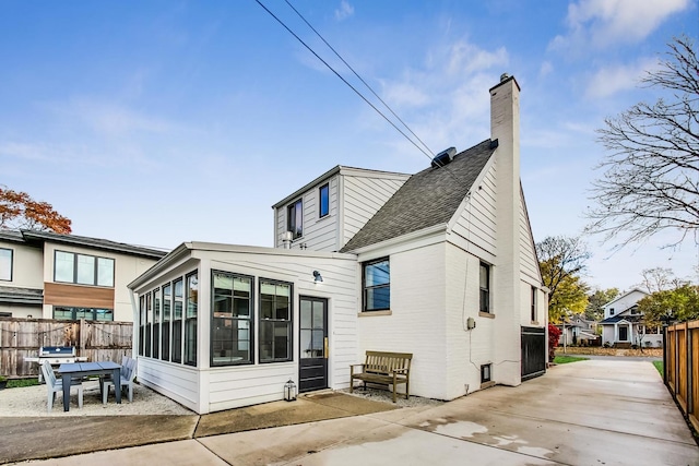 back of property with a patio area and a sunroom