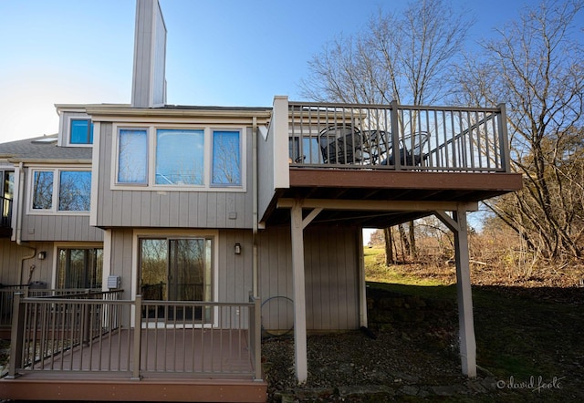 rear view of house featuring a wooden deck