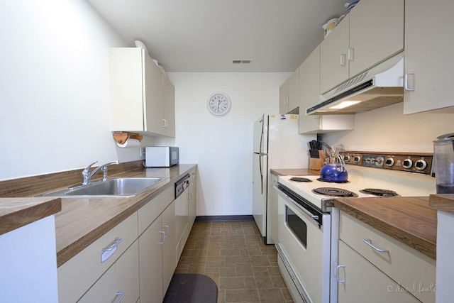 kitchen featuring white appliances, white cabinetry, and sink