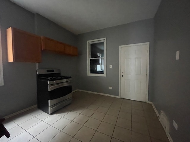 kitchen featuring light tile patterned floors and stainless steel gas range