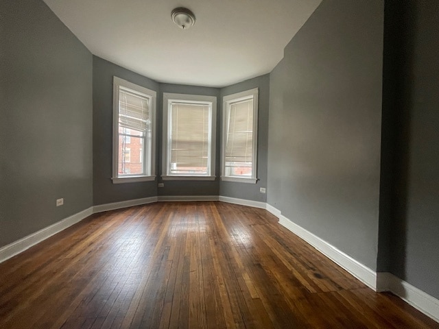 unfurnished room with dark hardwood / wood-style flooring